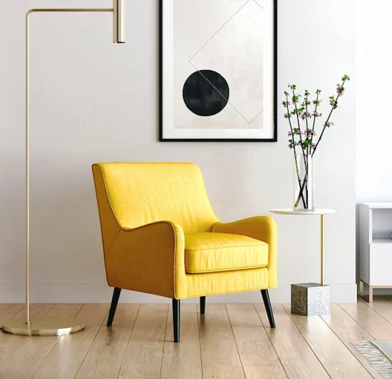 A yellow armchair in a contemporary room with a modern art piece hanging above it and a chrome floor lamp next to it.